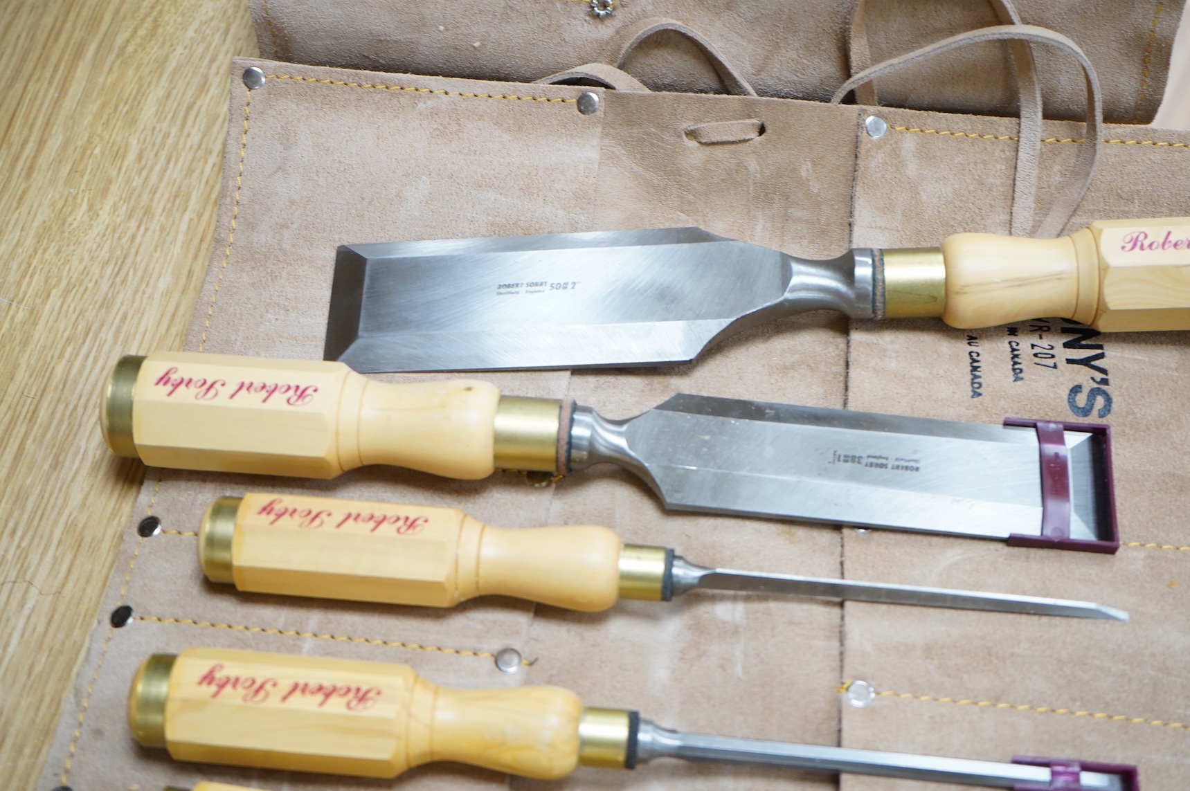Two sets of Robert Sorby woodworking chisels, both in Kuny’s of Canada leather tool rolls; a nine piece set with octagonal handles, together with a six piece set with rosewood handles